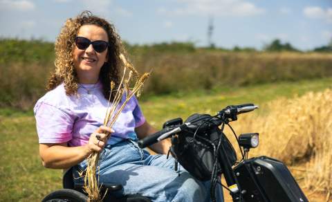 Carrie-Ann Lightley in a mobility scooter holding corn.