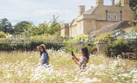 Two women walking through long grass at Bourton Hill Gardens