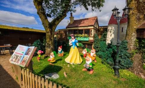 Models of Snow White and the Seven Dwarfs stand outside their cottage at Fairytale Farm
