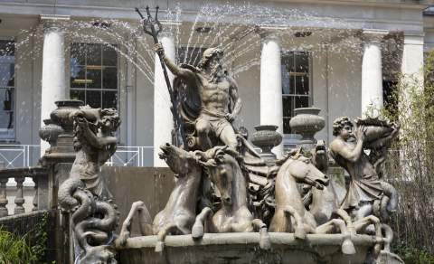 A large fountain depicting Neptune in a chariot drawn by four seahorses, accompanied by a merman blowing a conch shell