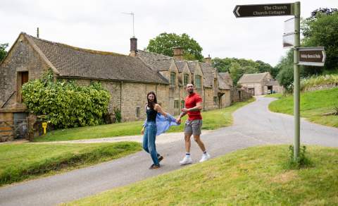A couple holding hands walking in Notgrove