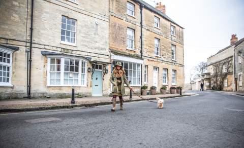 Woman wrapped up warmly taking her dog for a walk in Woodstock