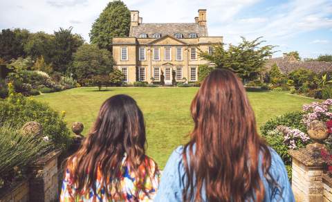 Two women looking across the lawn towards Bourton House