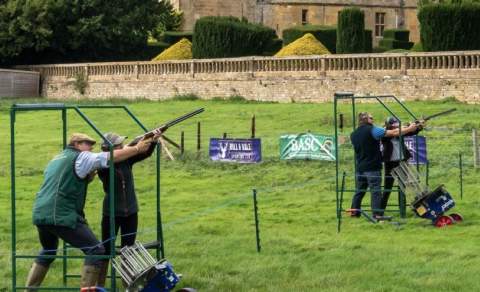 Two people are being taught clay pigeon shooting at Ian Coley Outdoor Pursuits