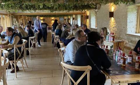 Groups of people sit at tables 'speed dating' in a large room