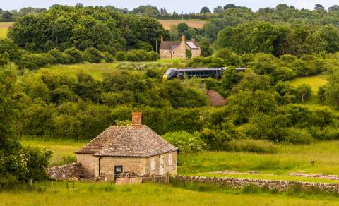 A view of North Leigh Roman Villa with a GWR train passing in the distance behind