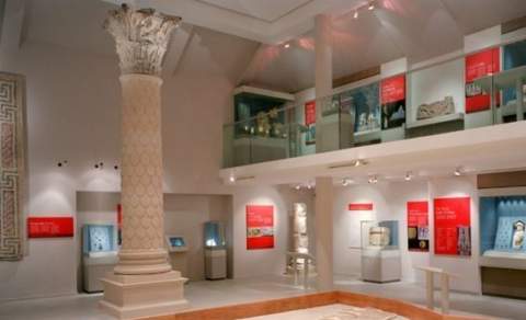 A gallery at the Corinium Museum with large column, artefacts and information boards