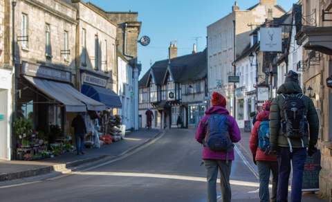 A group of people return from a countryside walk to Winchcombe