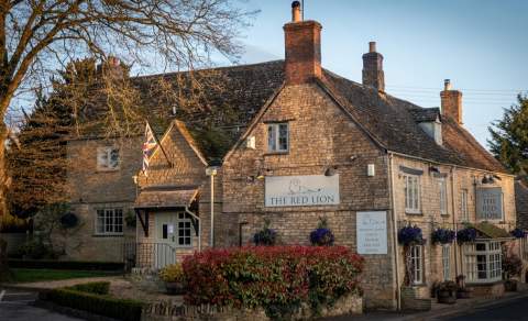 Evening sun lights up the Cotswold stone brickwork of The Red Lion Long Compton in the Cotswolds