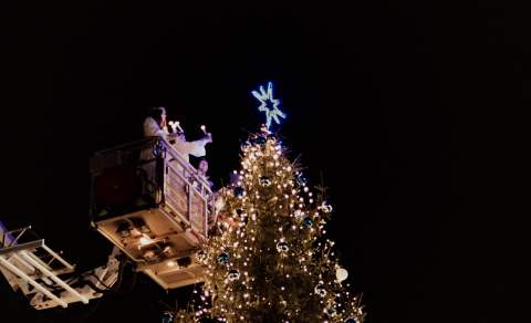 Lucia som tenner juletreet på torget i Sarpsborg fra en lift. Foto.