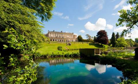 The stunning, Grade II listed Cowley Manor mansion lies in the distance with lush green lawns in front leading down to a large pond