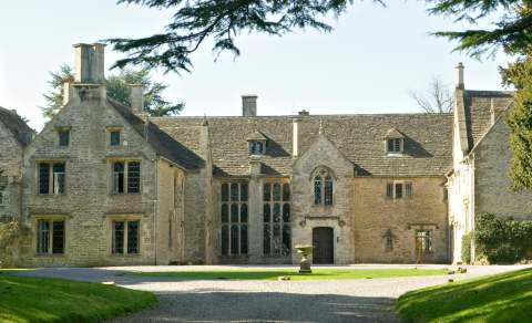 The front of Chavenage House, a Cotswold stone manor house surrounded by trees