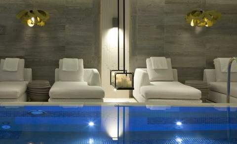 White luxurious loungers surround a tranquil indoor pool at The Dormy House in the Cotswolds