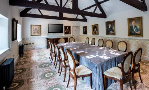 A large meeting room with high ceiling, wooden beams and antique paintings at Ellenborough Park