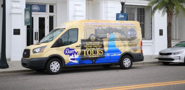 colorful passenger van parked in front of white building