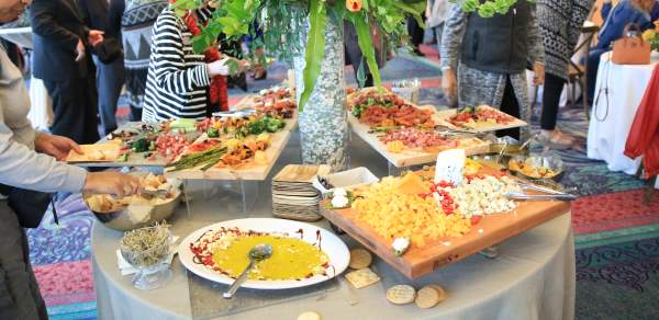 Table of catered food with people around it