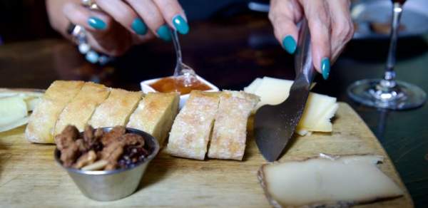 Charcuterie board with bread, nuts, cheese and preserves