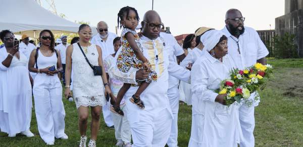 Group of African Americans holding flowers and marching in procession