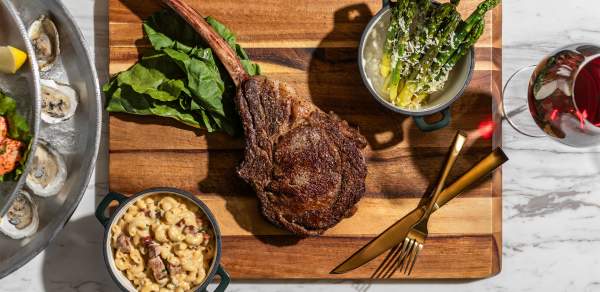 Overhead shot of meat and vegetables on a cutting board at Le Moyne's Chophouse in Mobile, AL things to eat