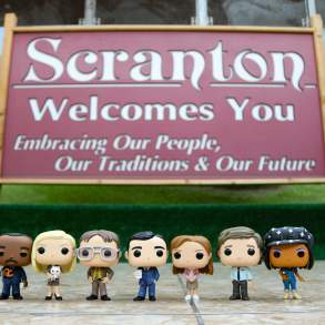 The Office characters at the Scranton Welcome sign