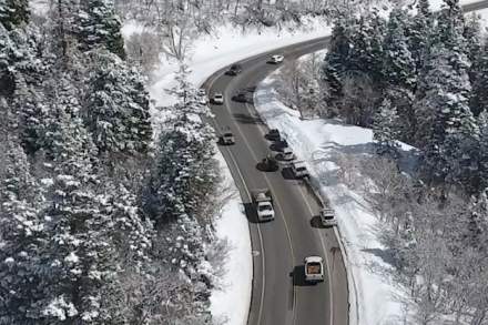Cars driving on a slightly wet road in a snowy canyon
