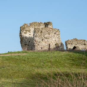 roman ruins on top of a grassy hill
