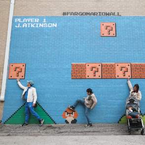 family interacting with mario mural