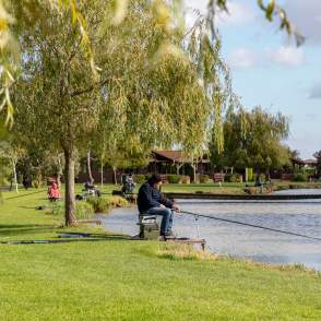 A man sat by a lake fishing