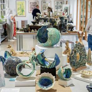 An exhibition space with pottery displays and people in background