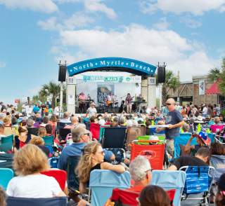 A crowd enjoys music on Main on a sunny day.