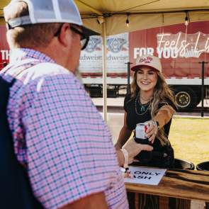 Bartender at the Feels like Home festival giving a festival goers a beer.