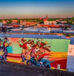 A beautiful mural adorns the brick of a public building on Garrison Avenue.