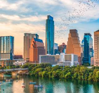bats flying from the congress bridge in front of Austin skyline at sunset