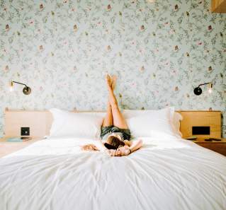Woman relaxing on bed at Arrive Austin hotel in Austin Texas