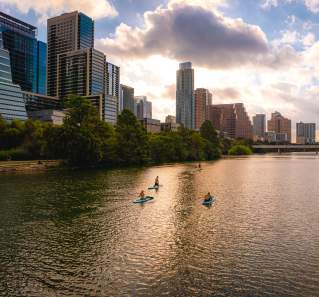 People stand up paddleboarding on Lady Bird Lake.