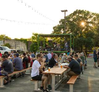 People drinking beer and sitting at patio tables at Barrow Brewing Company in Salado Texas