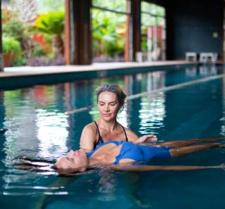 Image of two people floating in an indoor pool at Lake Austin Spa Resort.