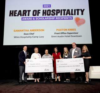 2021 Heart of Hospitality Award and Scholarship recipients posing with large checks from the Visit Austin Foundation.
