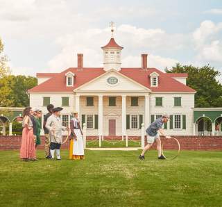 A family plays colonial games with interpreters at The American Village in Montevallo.