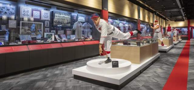 A statue of a pitcher in action stands in front of a wall of display cases.