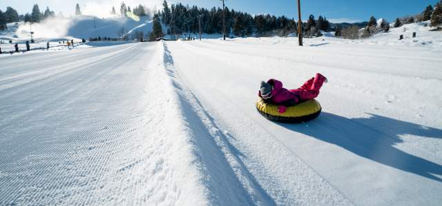 young kid going down a winter tubing track