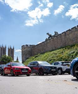 Castle Hill car park with cars in foreground and castle in background on sunny day