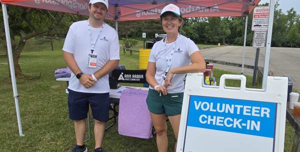Zack Buck and Meaghan Hughes under a tent with AnnArborSports.org
