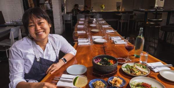Chef Ji Hye Kim at a table of Korean food
