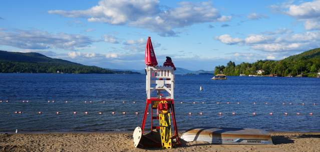Lifeguard chair on the beach facing Lake George and Adirondack Mountains