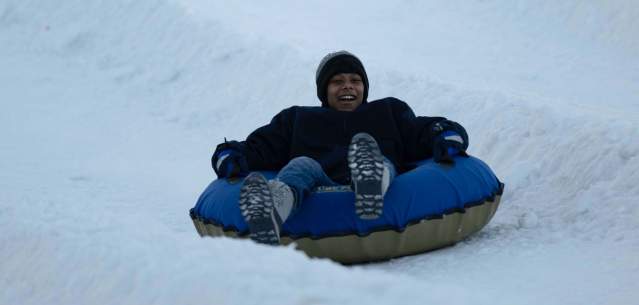 A boy tubing on West Mountain