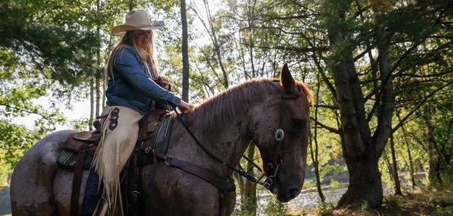 Woman horseback riding at 1000 Acres Ranch