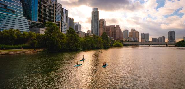 People stand up paddleboarding on Lady Bird Lake.