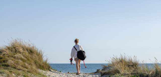 A lone traveller walks to the beach at East Head sand dunes in Sussex
