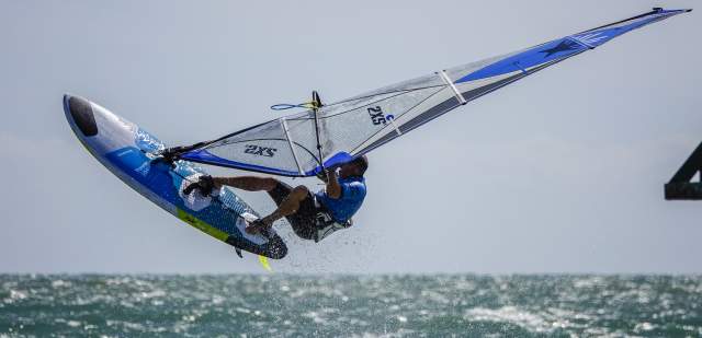 Man rides his windsurf above the sea at West Wittering beach, Sussex
